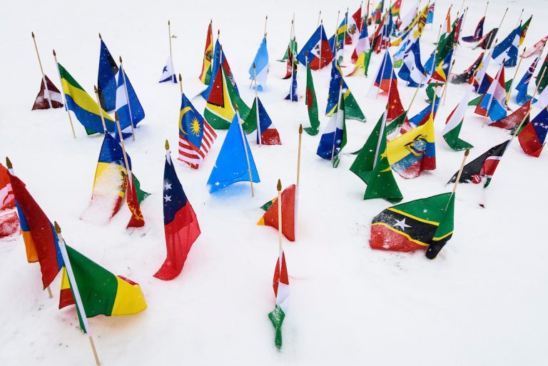 International flags -- part of a recruiting display promoting the Peace Corps -- flutter on Bascom Hill at the University of Wisconsin-Madison during a winter snowstorm with whiteout conditions on March 1, 2016. (Photo by Jeff Miller/UW-Madison)
